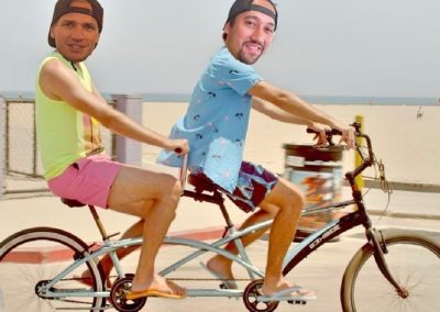 Owners of Purvé Donut Stop Hawaii riding a tandem bike on the beach