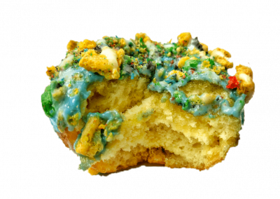 Blue mixed berry glazed donut topped with captain crunch berries and cream cheese drizzle from Purvé Donut Stop Hawaii showing the fluffy inside